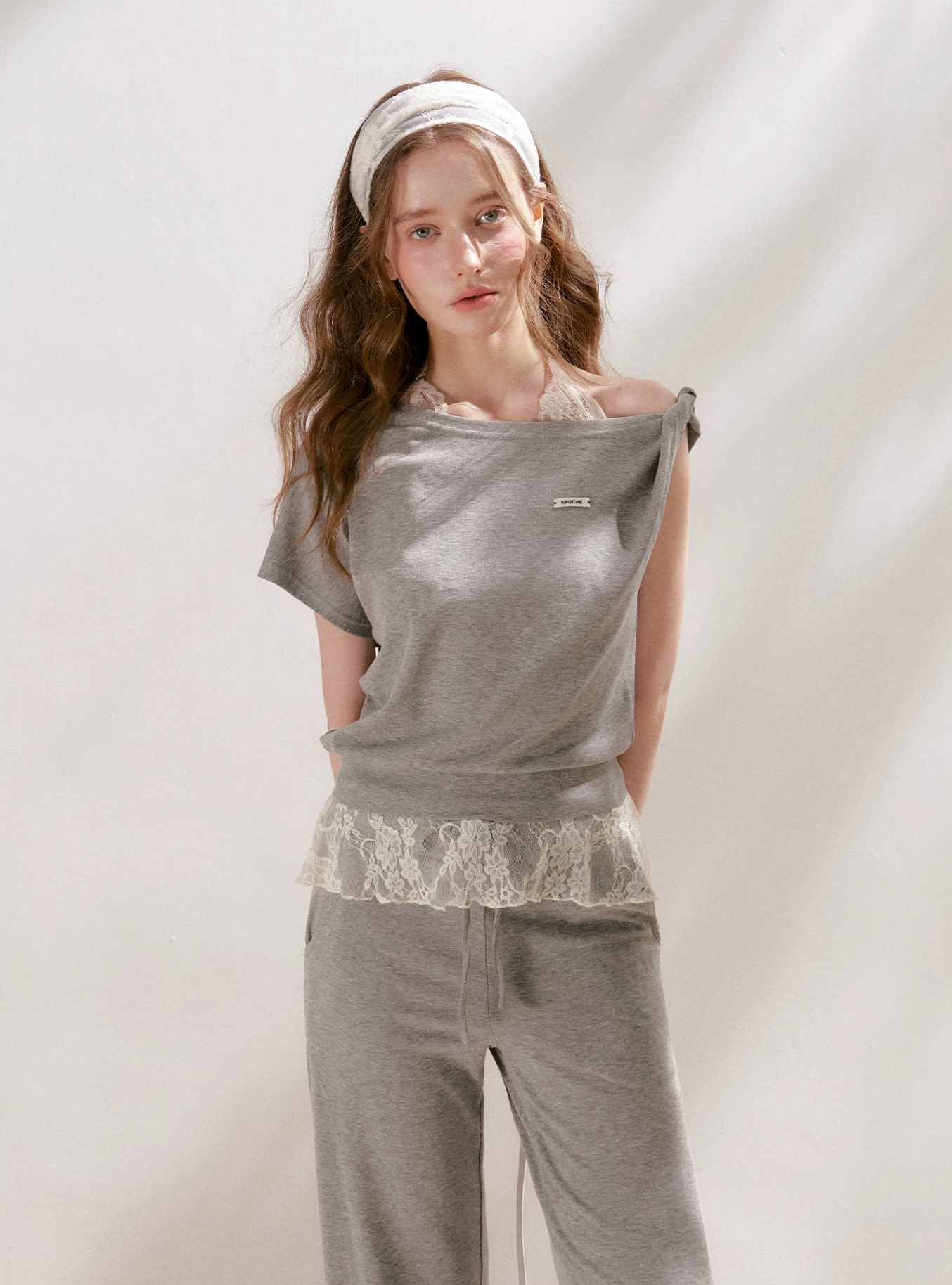 KROCHE Romantic French outfit includes a buttoned off-the-shoulder t-shirt and a halterneck lace tank top and wide-leg pants.
